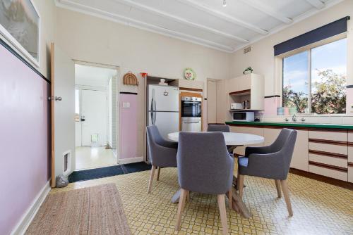 a kitchen with a table and chairs in a room at North Beach Cottage by Swan BnB Management in Perth
