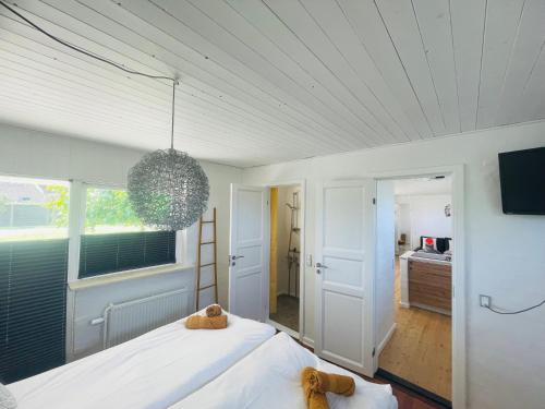 a bedroom with a large white bed and a window at Lejlighed Edelweiss in Svendborg