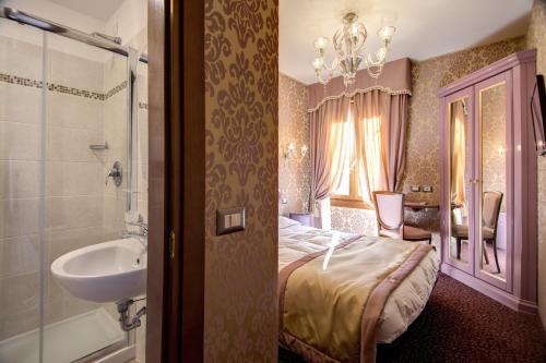 a bedroom with a bed and a sink and a bathroom at Domus Cavanis in Venice