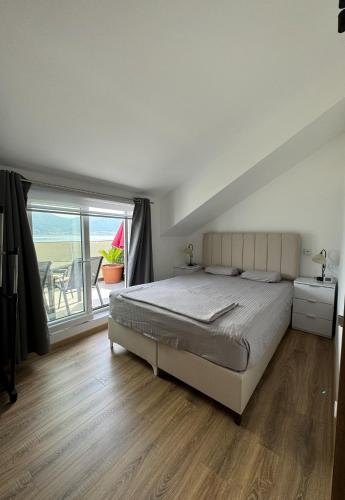 a bedroom with a bed and a large window at Blue sky apartman in Krašići