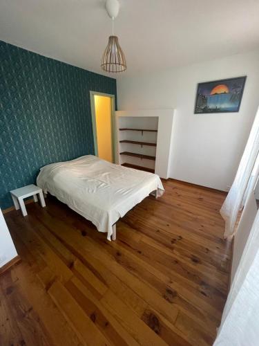 une chambre avec un lit et un parquet dans l'établissement Les Apparts du Langouyrou, à Langogne