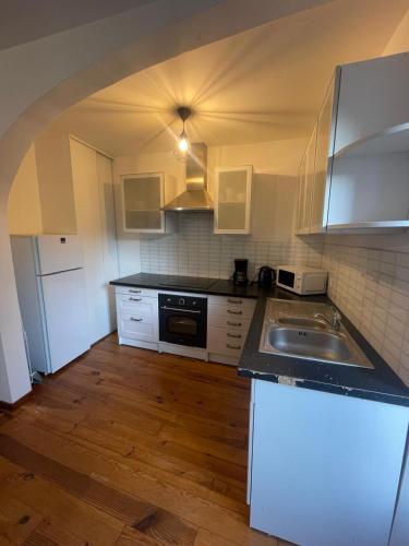 une cuisine avec un évier et une cuisinière four supérieur dans l'établissement Les Apparts du Langouyrou, à Langogne