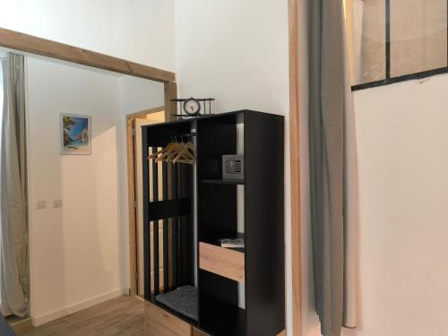 une étagère noire dans un couloir avec un miroir dans l'établissement Chez Nico et Mag entre mer et collines, à Aubagne