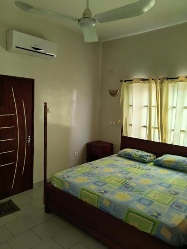 een slaapkamer met een bed en een raam bij Ouslane Appart-1 in Cotonou