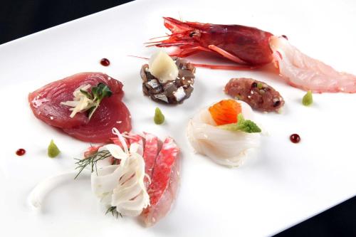 a white plate with different types of food on it at Il Cascinalenuovo in Asti