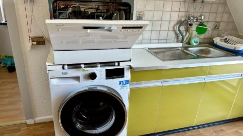 a washing machine in a kitchen next to a sink at Traveller Awards 2025 - Nordeifel FW 75 m2 mit 50 m2 Terasse- Thermen-Badewelt, Phanasialand, Köln, Bonn, Eifelwanderung oder nur mal so zum entspannen in Euskirchen