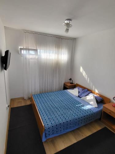 a bedroom with a blue bed and a window at Vila Hipo in Venus
