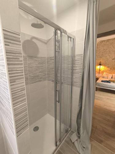 une douche avec une porte vitrée dans une salle de bain dans l'établissement Chez Nico et Mag entre mer et collines, à Aubagne
