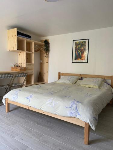 - une chambre avec un grand lit et un cadre en bois dans l'établissement La chambre du moulin, à Saint-Cyr-sur-Mer