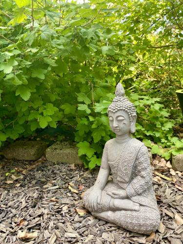 a statue of aitating woman sitting in the ground at Ferienwohnung Am Wäldchen in Erfurt