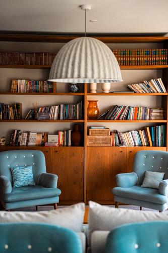 a living room with two chairs and books at Hotel Vouga in Termas de Sao Pedro do Sul