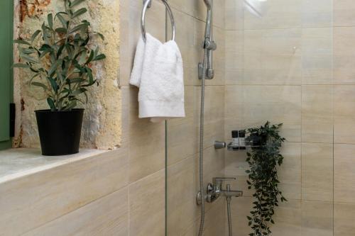 a shower with a white towel hanging on a wall at Villa Sevastoula (formerly Villa Skalita) in Ratzaklíon