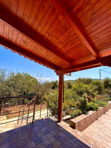 a wooden pergola with a view of a garden at Guesthouse Nedin in Ksamil