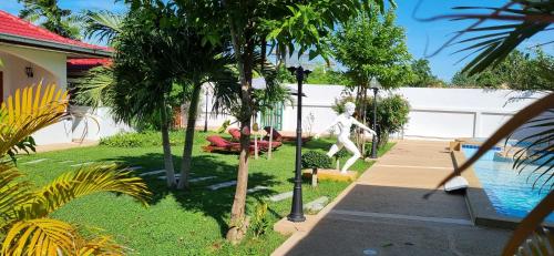 a garden with a statue next to a pool at Meyers Hua Hin in Hua Hin