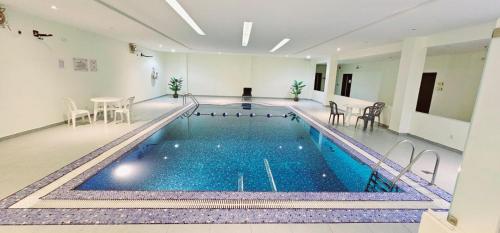 a swimming pool with blue water in a building at Celine Home Serviced Apartment Al Malqa in Riyadh