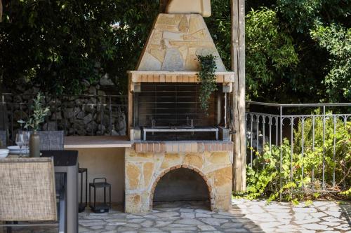 a outdoor oven with a stone fireplace in a yard at Villa Zoe (formerly Villa Eboros) in Ratzaklíon