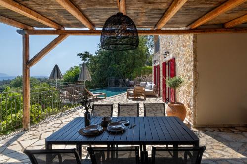 a patio with a table and chairs and a pool at Villa Zoe (formerly Villa Eboros) in Ratzaklíon