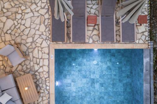 an overhead view of a swimming pool with a stone wall at Villa Zoe (formerly Villa Eboros) in Ratzaklíon
