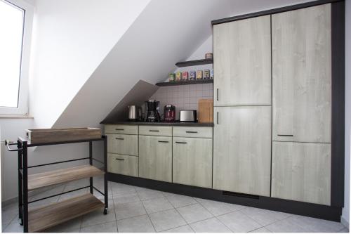 a kitchen with white cabinets and a staircase at Sonne, Mond und Sterne in Moritzburg