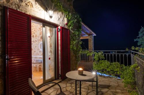 a candle on a table on a balcony at night at Villa Zoe (formerly Villa Eboros) in Ratzaklíon