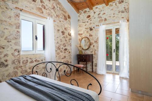 a bedroom with a bed in a room with stone walls at Villa Zoe (formerly Villa Eboros) in Ratzaklíon