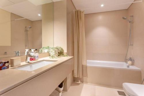 a bathroom with a sink and a bath tub at Modern2BR ElegantYas Island703 in Abu Dhabi