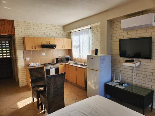 a small kitchen with a refrigerator and a tv at Golden Dawn Chalets in La Mercy