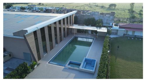 VidishaにあるThe Riverside Innのプールのある建物の上空からの眺め