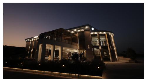VidishaにあるThe Riverside Innの夜にライトが点灯する大きな建物