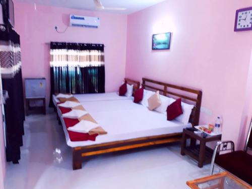 a bedroom with a large bed with red and white pillows at Samant Beach Resort in Malvan