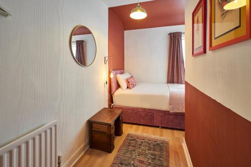 ein kleines Schlafzimmer mit einem Bett und einem Spiegel in der Unterkunft Hideaway in Amble