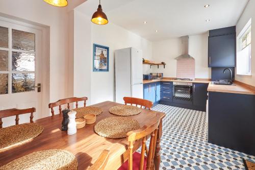 a kitchen with a wooden table with chairs and a dining room at Hideaway in Amble