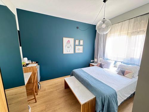 a blue bedroom with a bed and a window at Be My Guest Athens in Athens