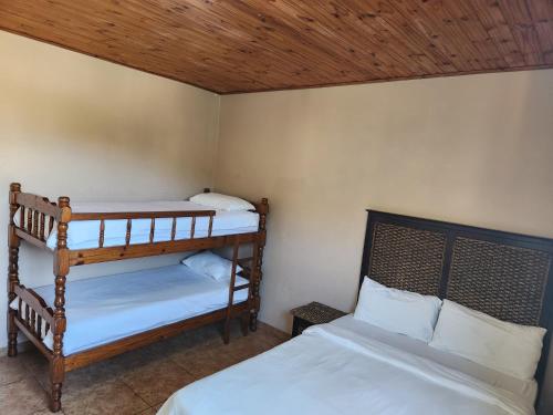 a bedroom with two bunk beds and a wooden ceiling at Golden Dawn Chalets in La Mercy