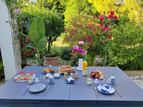 une table bleue avec des aliments pour le petit-déjeuner dans l'établissement SERINITY, à Sainte-Soulle
