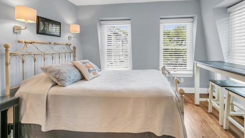 a bedroom with a bed and two windows at Tandem Bike Inn in Belmar