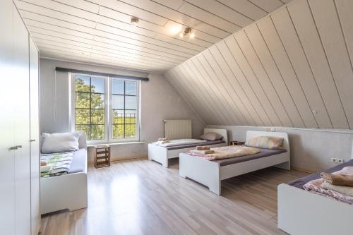 a attic room with two beds and two couches at Arbeitnehmerunterkunft 6 Personen mit großer Terrasse in Sulzheim