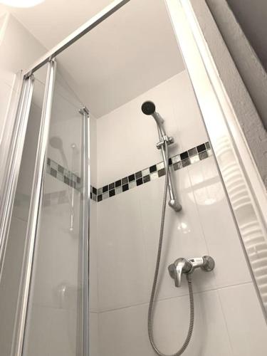 une douche dans une salle de bain avec une porte vitrée dans l'établissement Appartement Haussmanien au coeur du village Montmartre !, à Paris