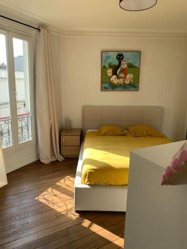 - une chambre avec un lit doté de draps jaunes et une fenêtre dans l'établissement Appartement Haussmanien au coeur du village Montmartre !, à Paris