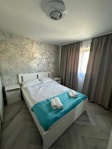 a bedroom with a bed with two towels on it at Davinci Apartment in Sibiu