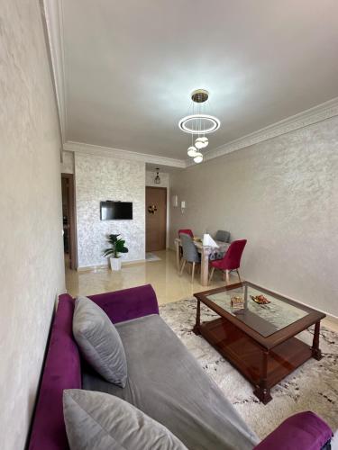 a living room with a purple couch and a table at Appartement Tanger in Tangier