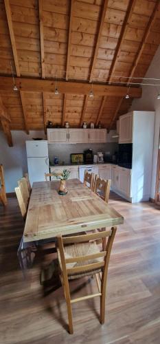 une table de salle à manger avec des chaises et une cuisine dans l'établissement Profiter en Famille au Viscos., à Geu