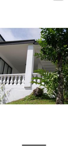 a white house with a tree in front of it at Ogumka 2 , self catering , Santa Maria , Mahe , Seychelles in Anse Royale