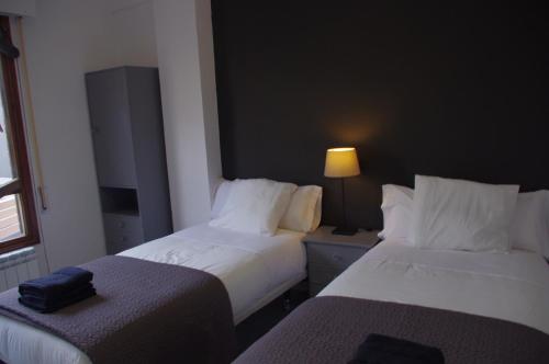a hotel room with two beds and a lamp at Riojania El Vino in Calahorra