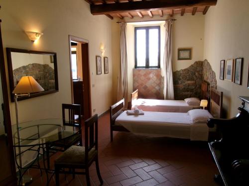 Schlafzimmer mit einem Bett, einem Fenster und einem Tisch in der Unterkunft Agriturismo Fattoria di Malavolta in Florenz