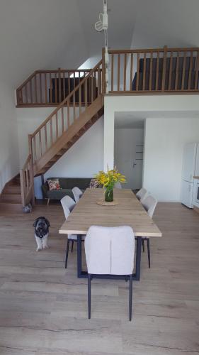 a dining room with a table and a cat sitting around it at Bukowska House in Sulechów