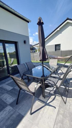 two chairs and a table with an umbrella on a patio at Bukowska House in Sulechów