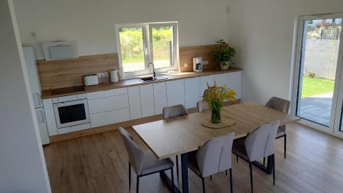a kitchen with a wooden table and chairs in a room at Bukowska House in Sulechów