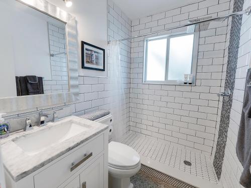 a white bathroom with a sink and a toilet at Seas the Day 1BR, Next to the Beach in West Palm Beach