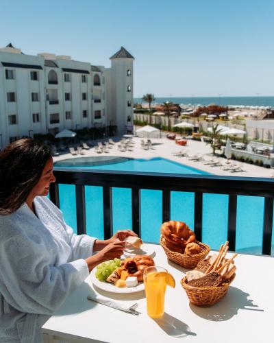 a woman sitting at a table with a plate of food at Palma Hotel in Port Said